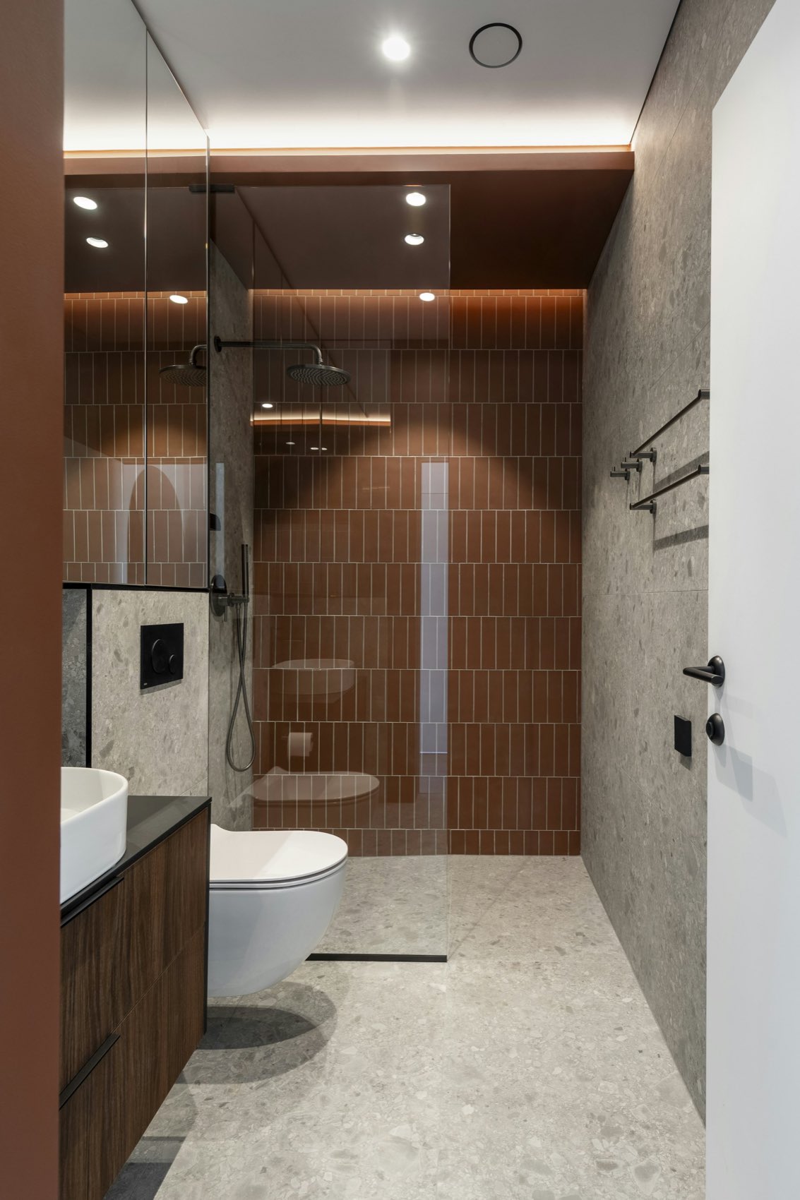 A KREM-tiled bathroom — terracotta metro shower wall and stone-look floor